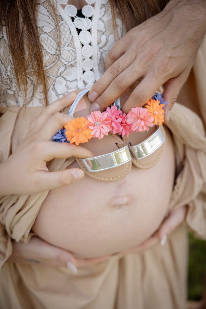 Frau mit Babybauch und Babysandalen – Babybauchfotografie bei M. Pictures by Madeleine